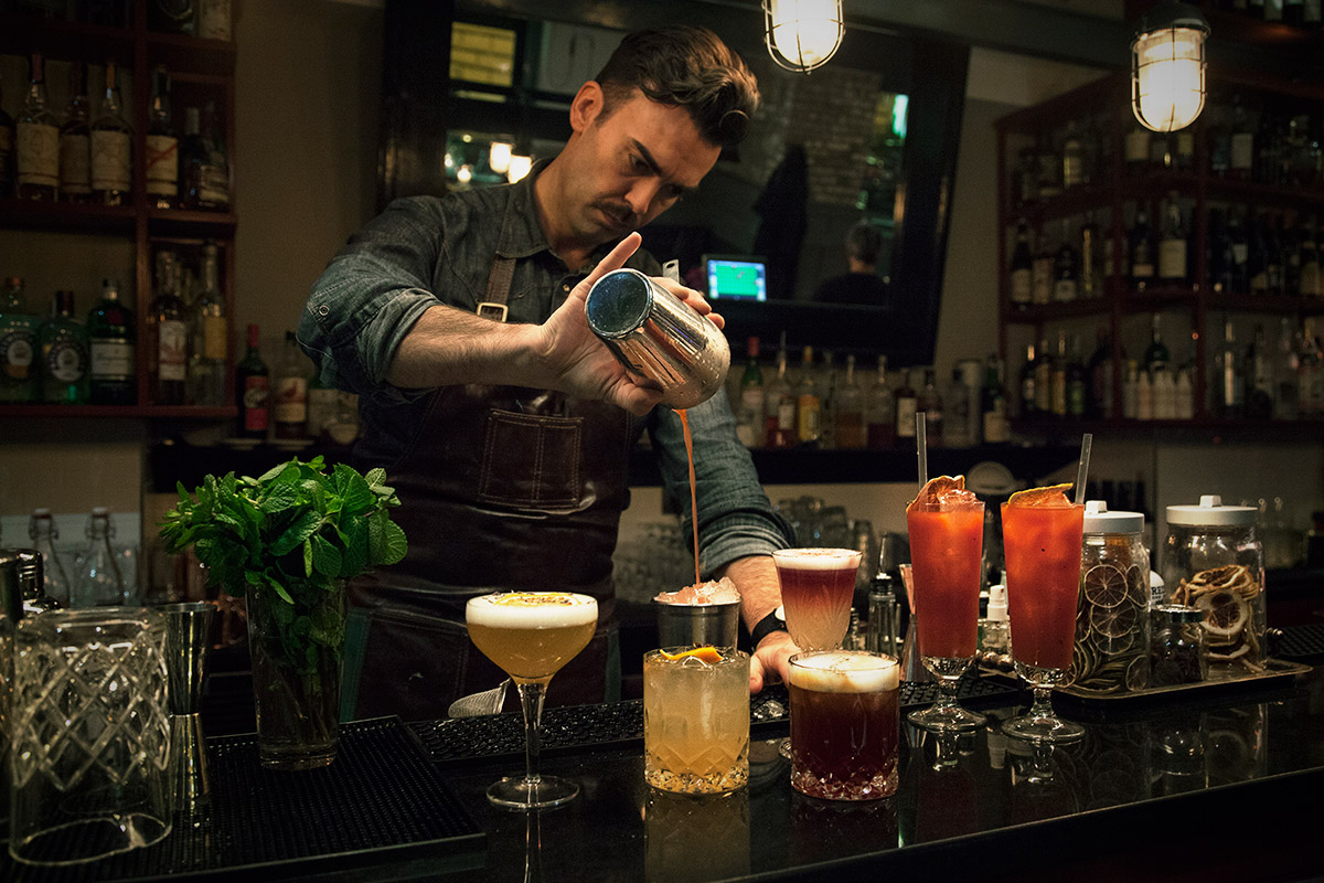 Il bartender di FUOCO prepara cocktail al bancone del bar